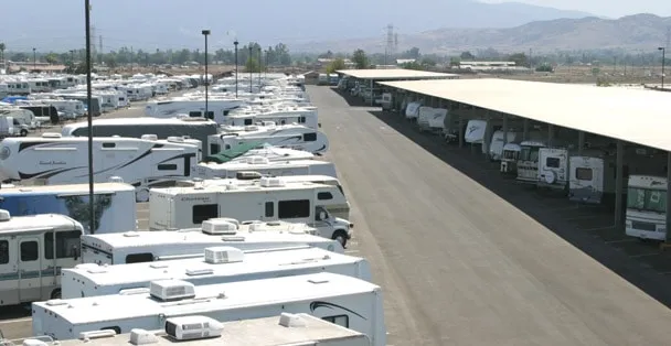 RVs and travel trailers parked in rows at an outdoor RV storage lot