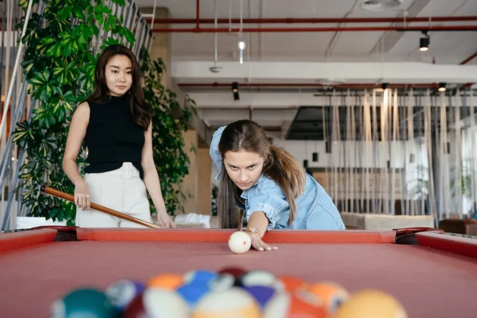 Two girls playing pool.