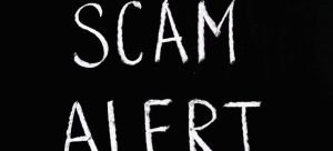 Scam alert written in white on a black surface