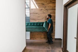 Man in blue denim jeans sitting on a green sofa