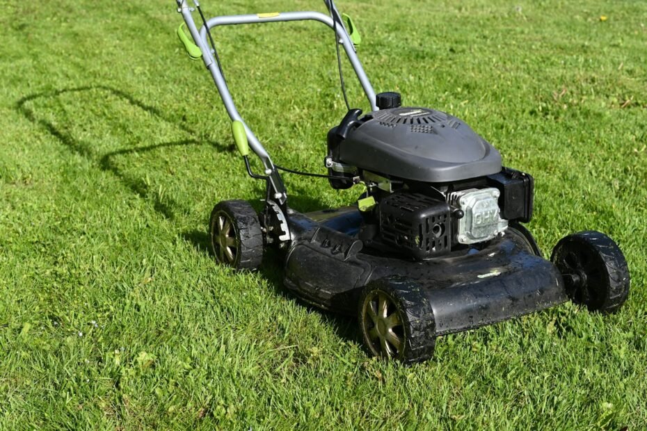 Gas push lawn mower on grass ready to be winterized before winter storage